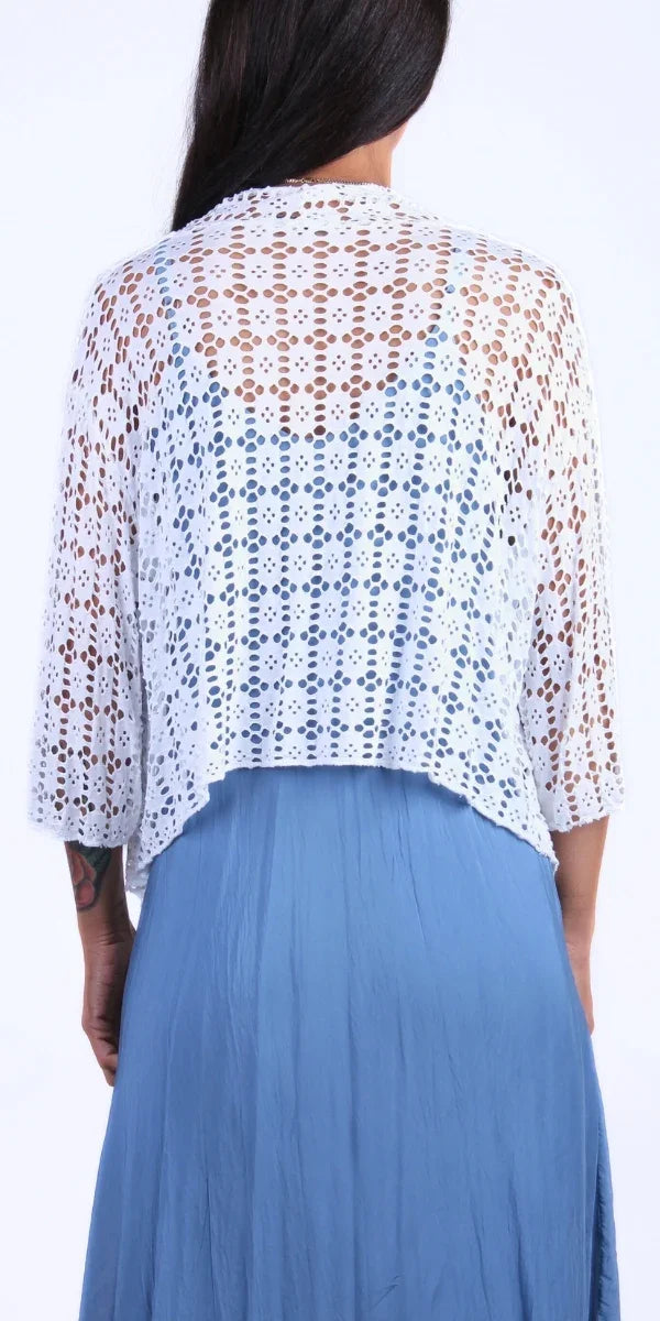 Back view of a woman wearing a white crochet lace cardigan over a blue dress