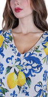 Woman wearing v-neck blouse with blue and yellow lemon floral print design