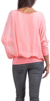 Back view of woman wearing a loose pink silk top and gray jeans, casual fashion